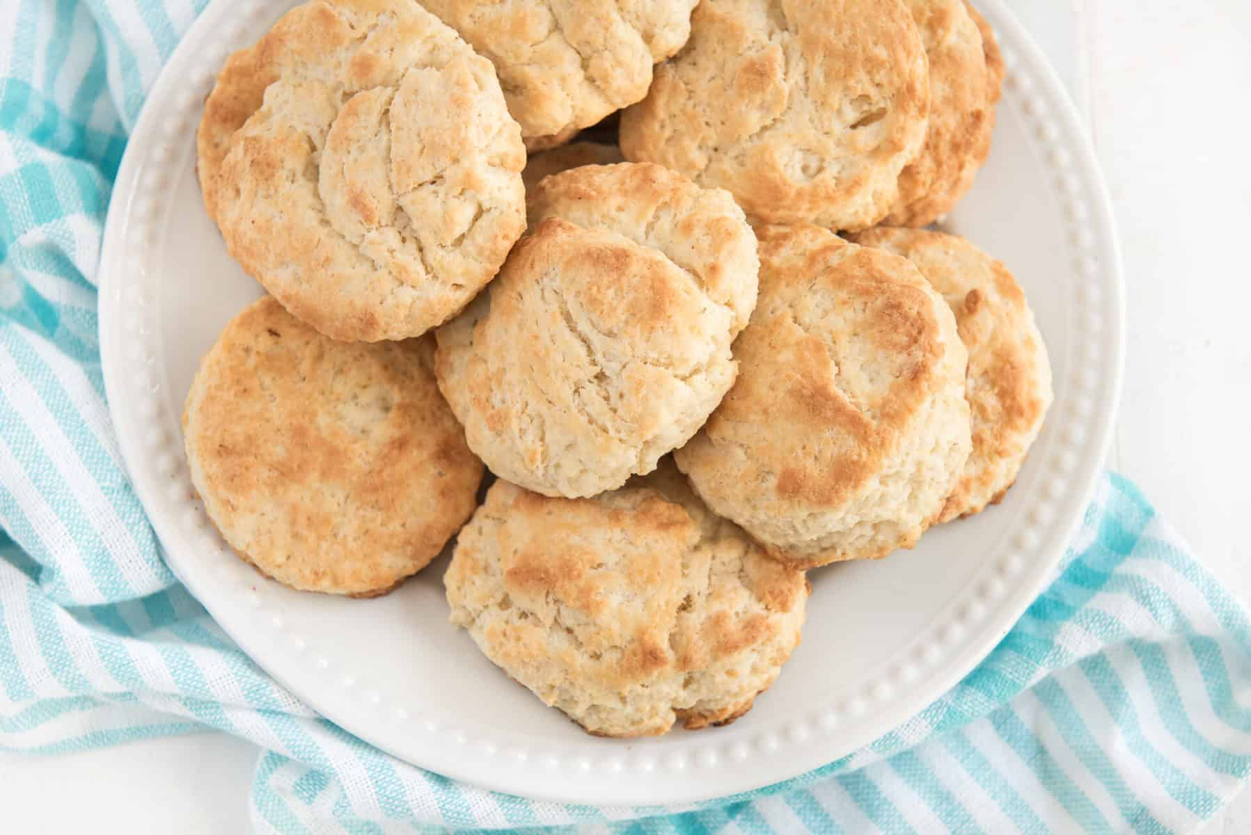 a white plate full of golden brown biscuits.