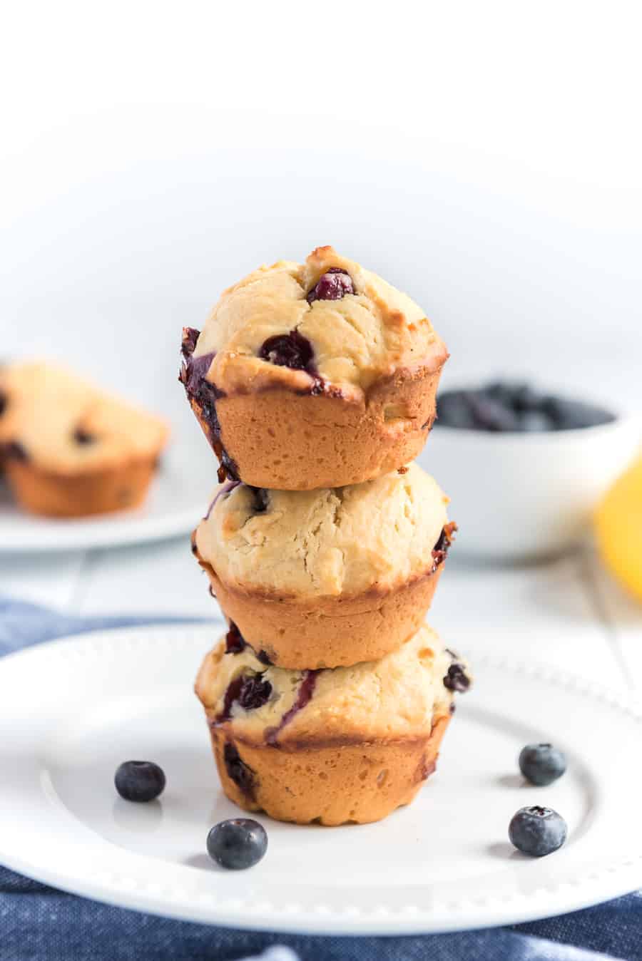 three blueberry lemon muffins stacked on top of one another