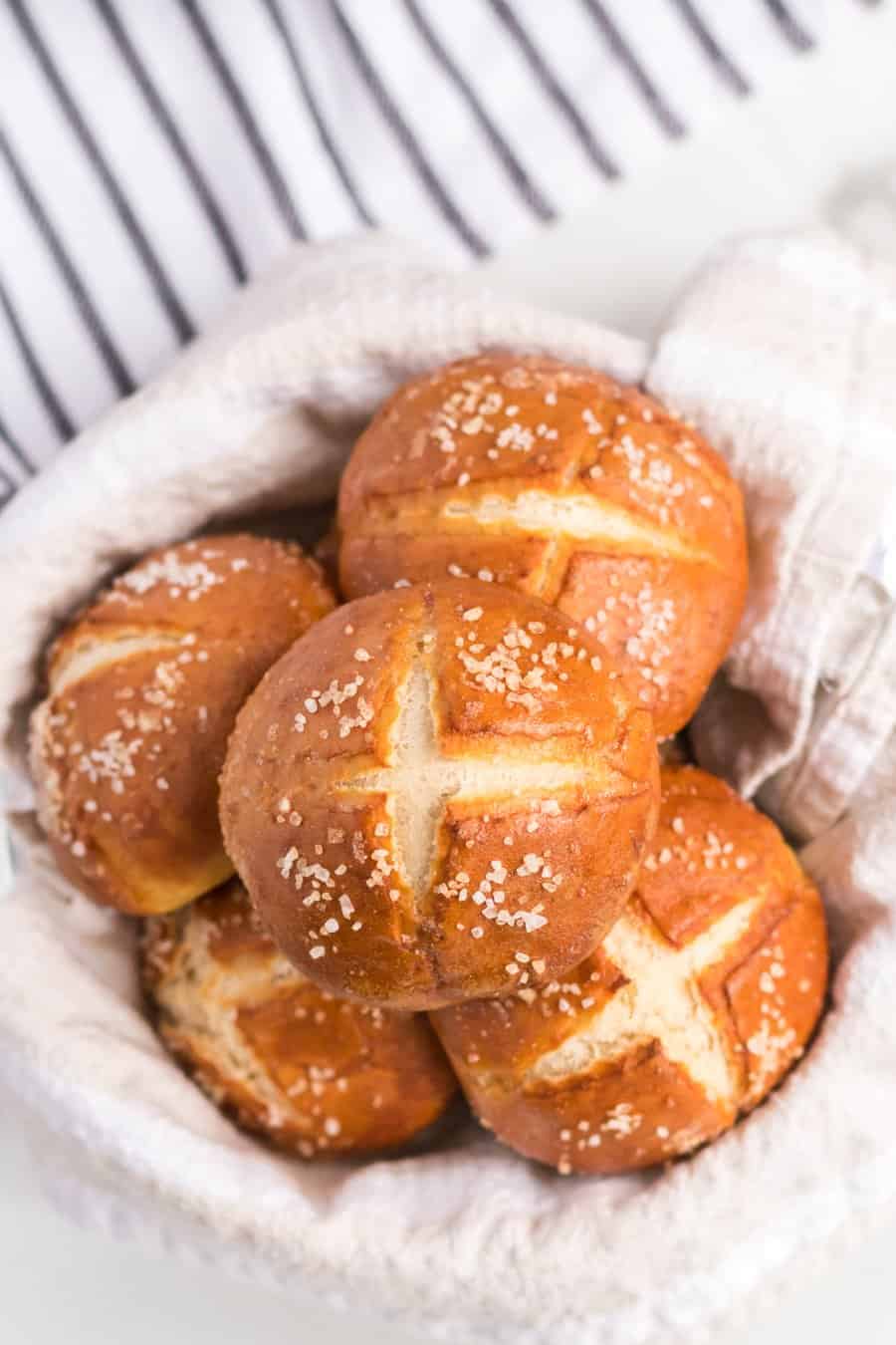 an overhead shot of some pretzel rolls in a linen lined bowl.