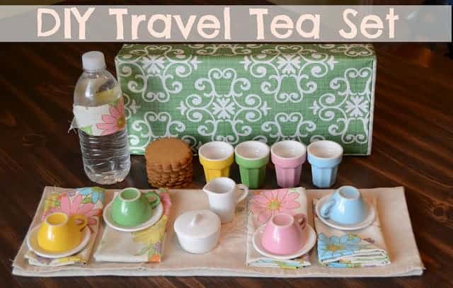 Title image for DIY Travel Tea Set and a set of colorful tea cups and saucers on floral napkins and a stack of cookies