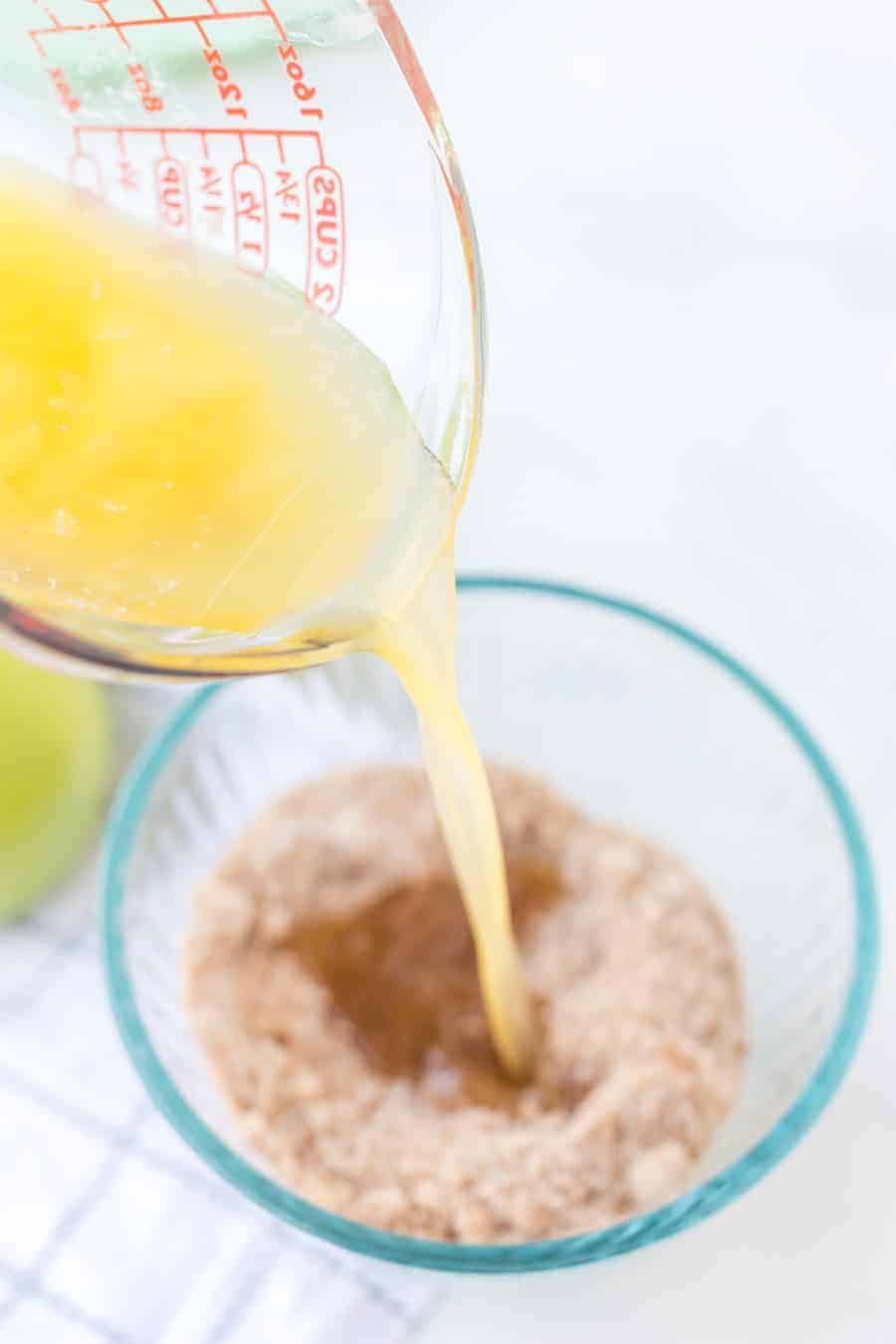apple crumble topping with butter being poured into it