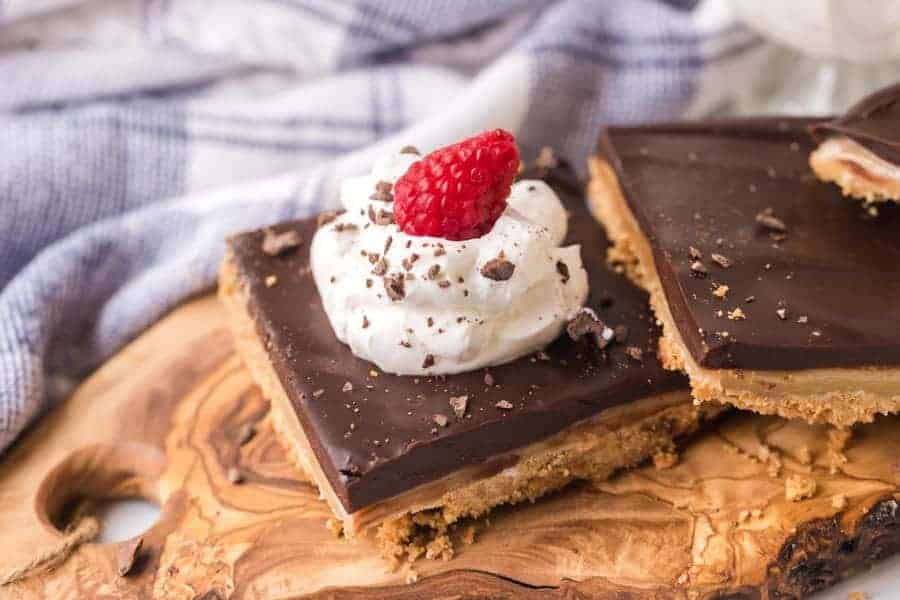 chocolate caramel tart with whipped cream and a raspberry on top.