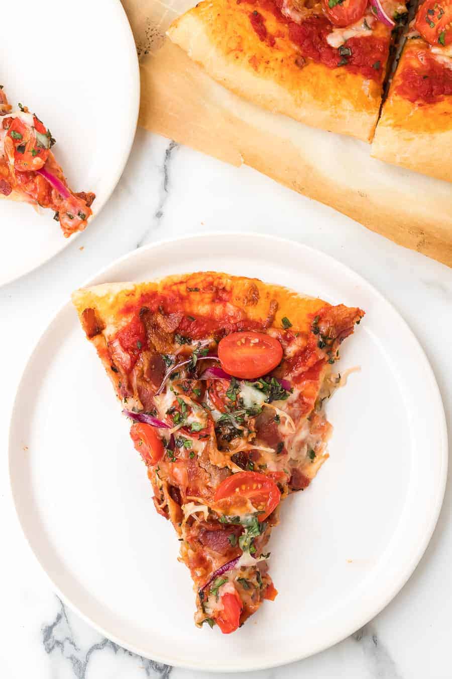 baked slice of pizza on white plate.