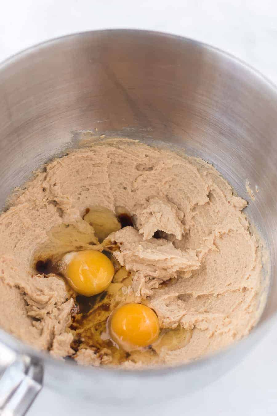 a bowl of cookie dough with two raw eggs in it.