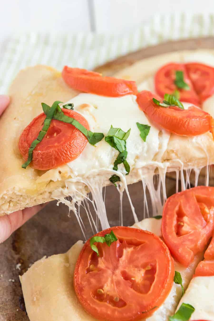 pov pulling apart a classic margarita pizza.
