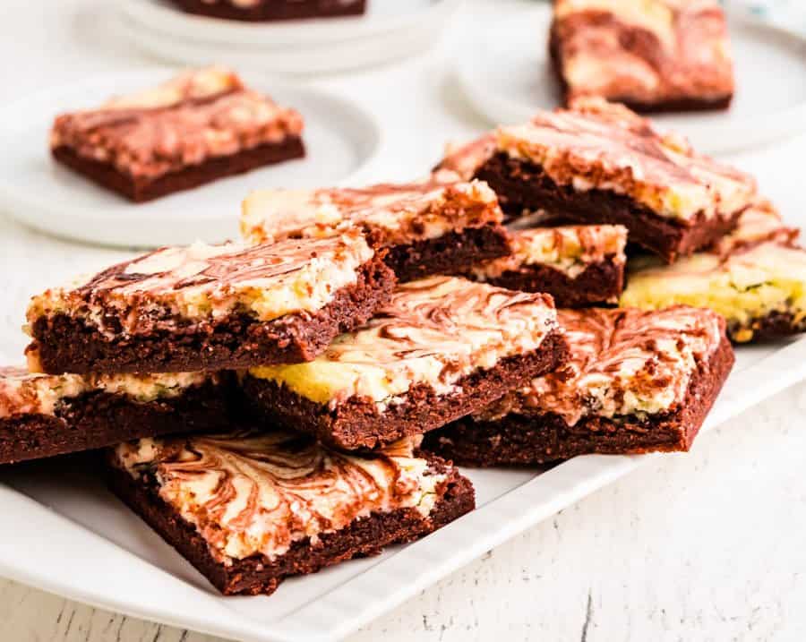 red velvet cheesecake bars stacked on a platter