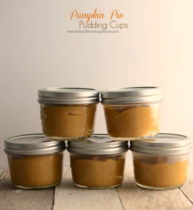 pumpkin pudding in small glass jars on wooden table.