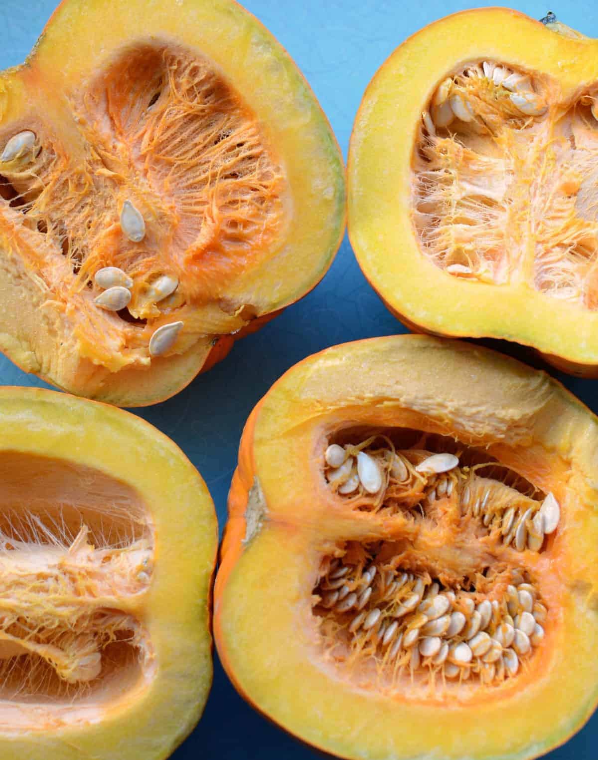 Top view of two pumpkins cut through the middle to show their innards.