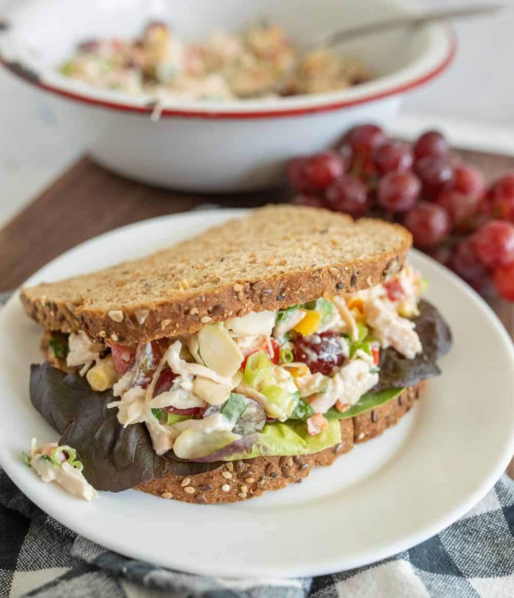 chicken salad sandwich made with whole grain bread and lettuce sitting on a white plate