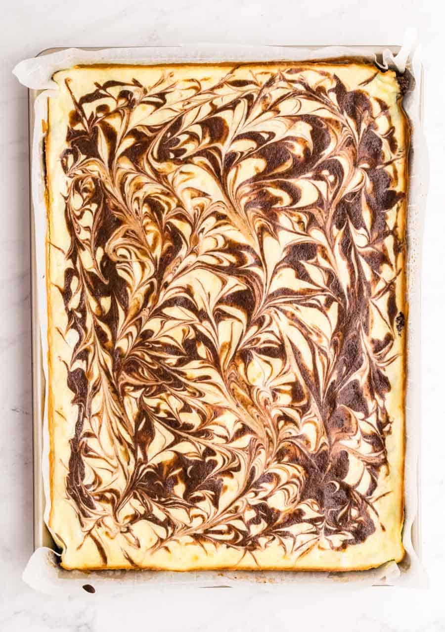 Top view of a pan of swirled cheesecake brownies.