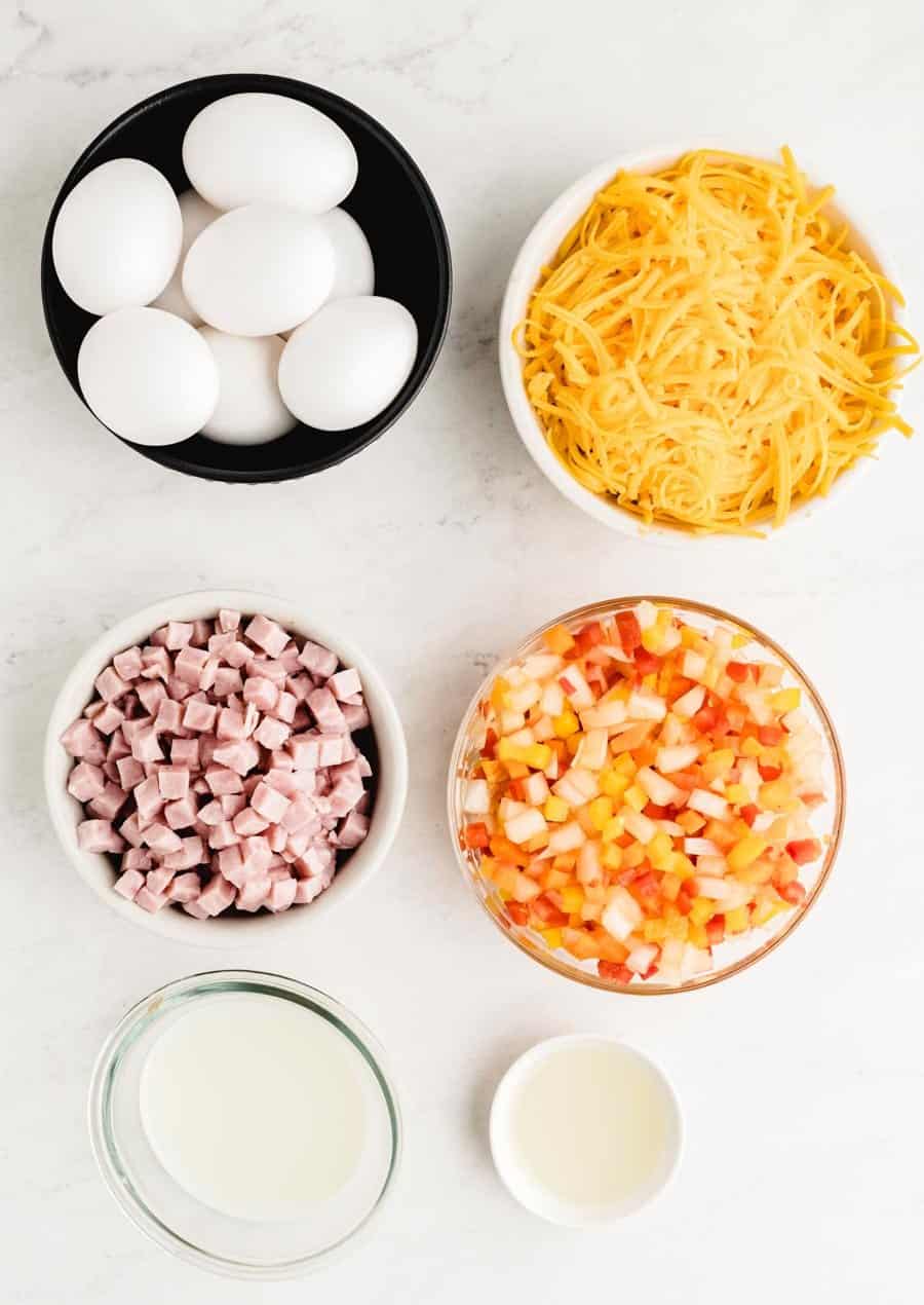 Top view of the ingredients for Denver omelet in individual bowls.