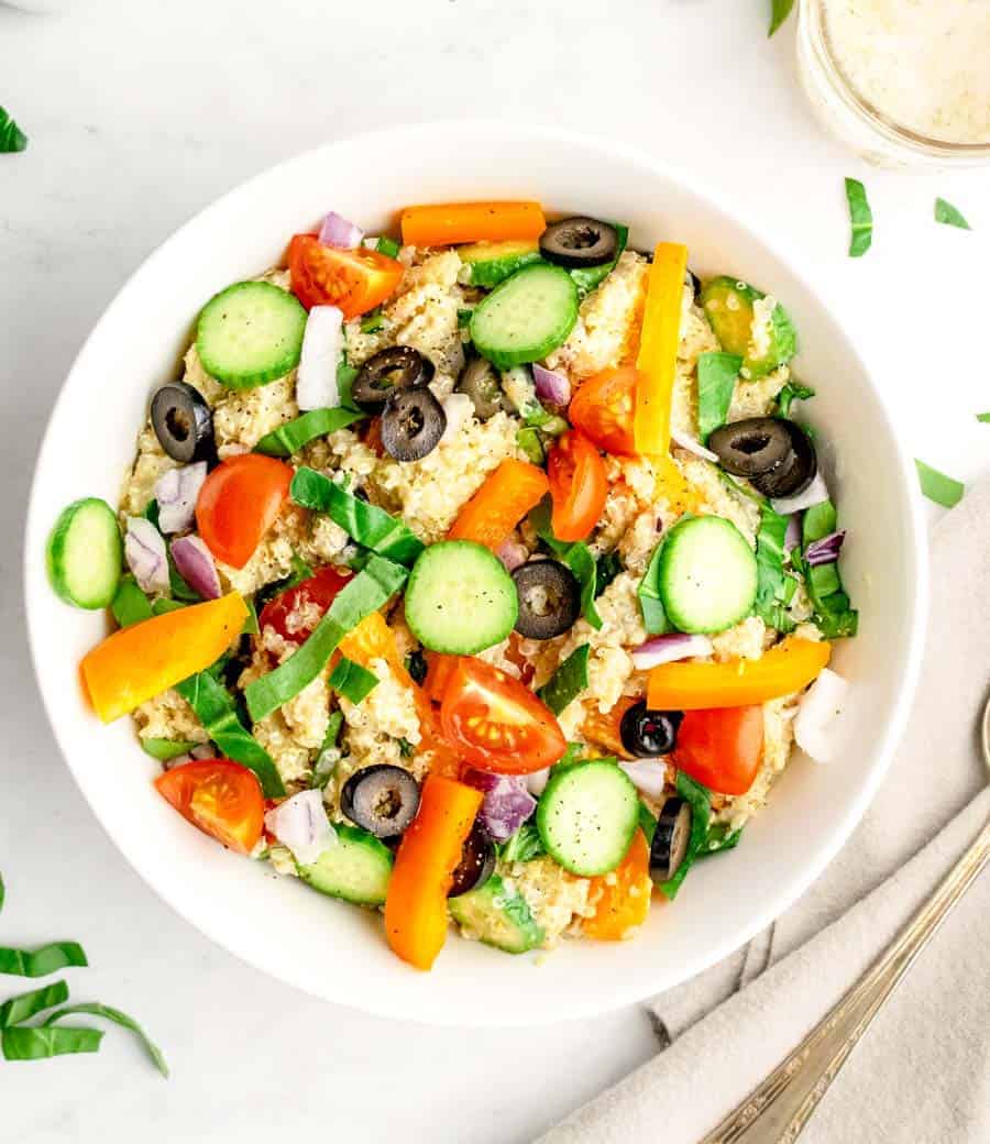 A top view of a bowl of quinoa salad in a white bowl.