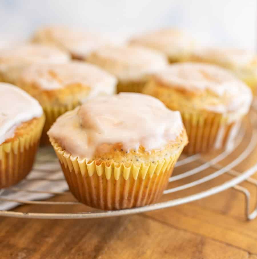 A close up picture of lemon poppy seed muffins on a rack.
