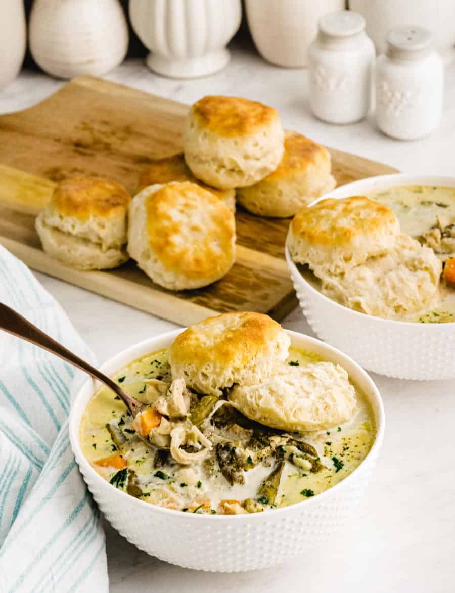 Two bowls of chicken pot pie with biscuits.