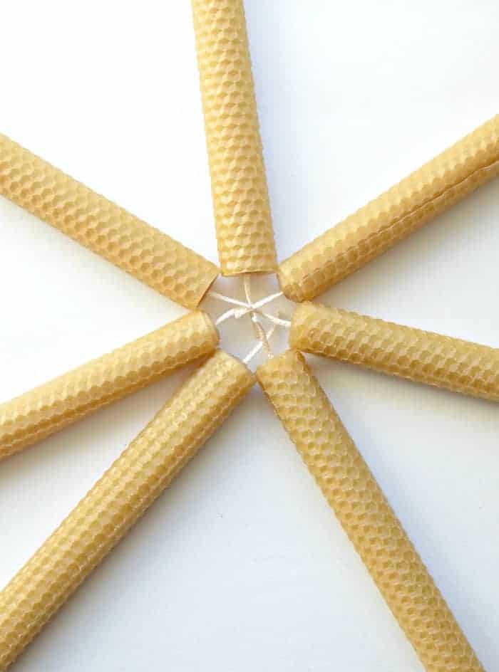Seven Simple DIY Beeswax Candles in a star shape on a white counter.