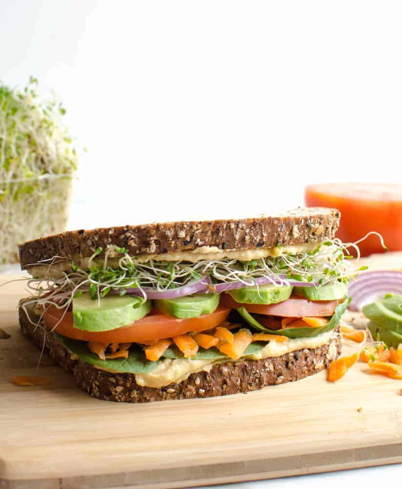 The Ultimate Hummus and Veggie Sandwich surrounded by ingredients.