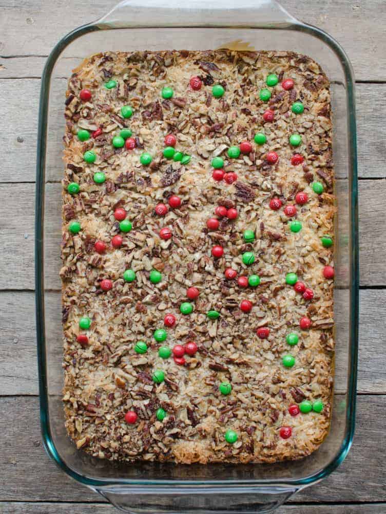 Top view of a full pan of Christmas Magic Cookie Bars in a clear glass baking pan.