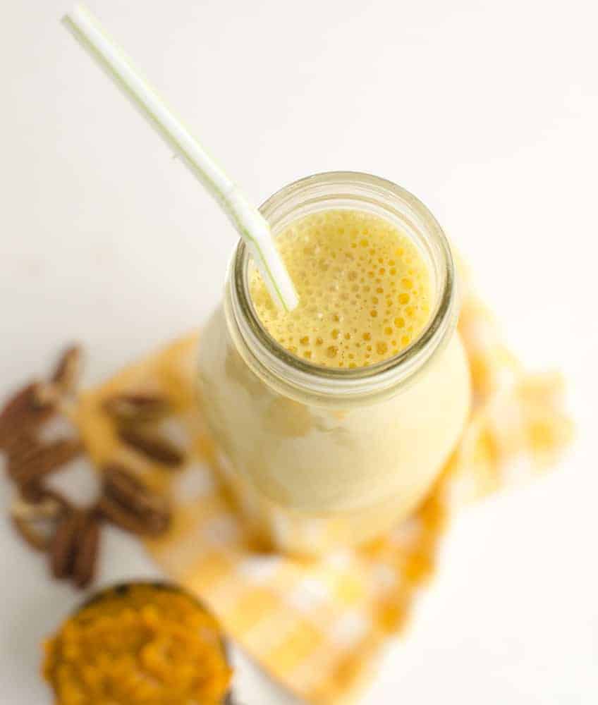 A glass milk jar with pumpkin smoothie recipe from a top view.