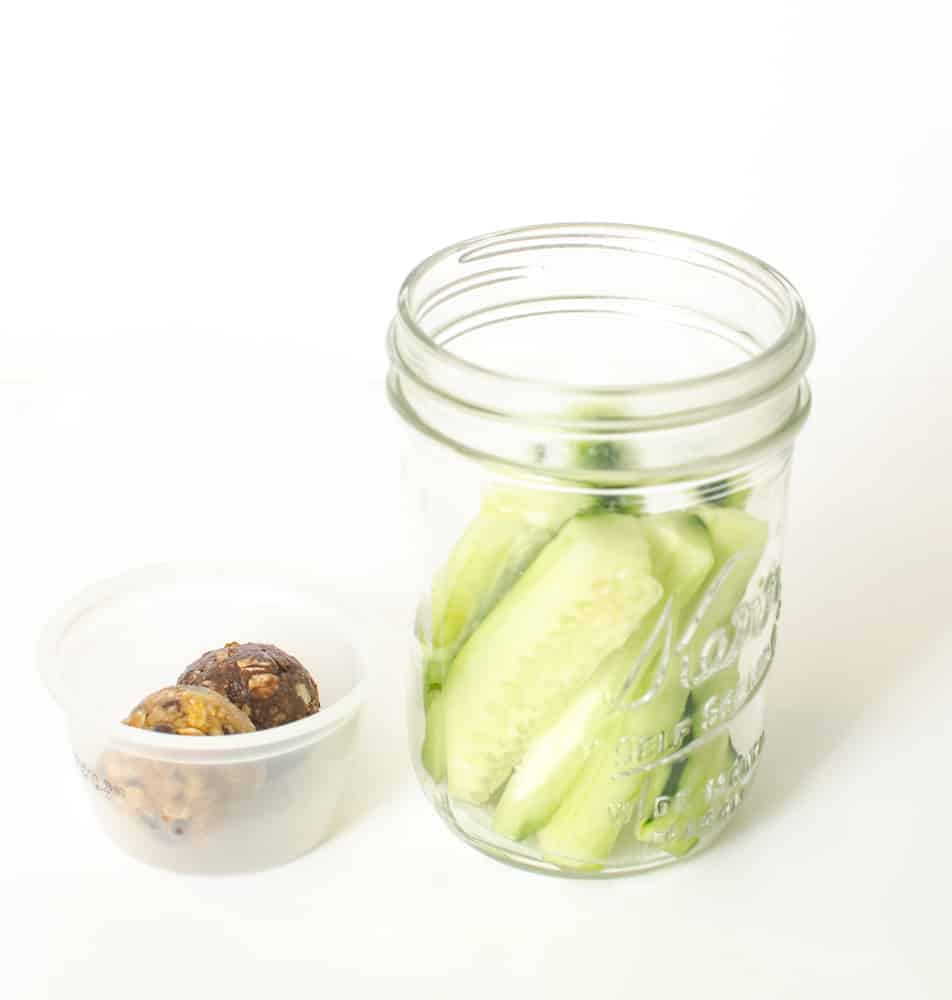 Cucumber spears and date balls in a Mason jar.