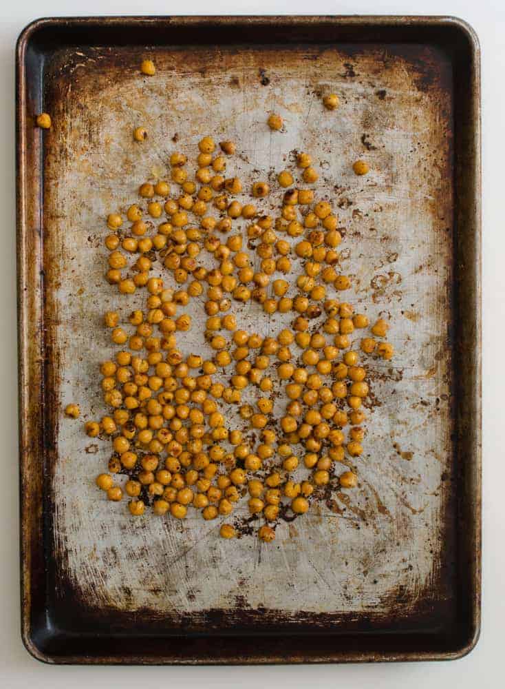 Roasted chickpeas on a rimmed baking sheet.