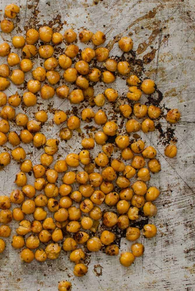 Close-up of roasted chickpeas on a baking sheet.