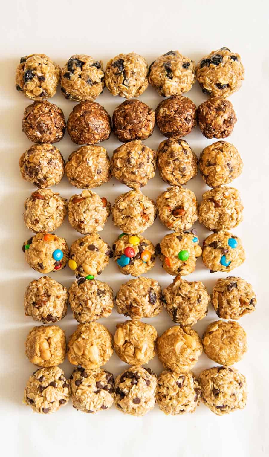 all 8 kinds of oatmeal energy balls all lined up in a 5 by 8 pattern on a white board.