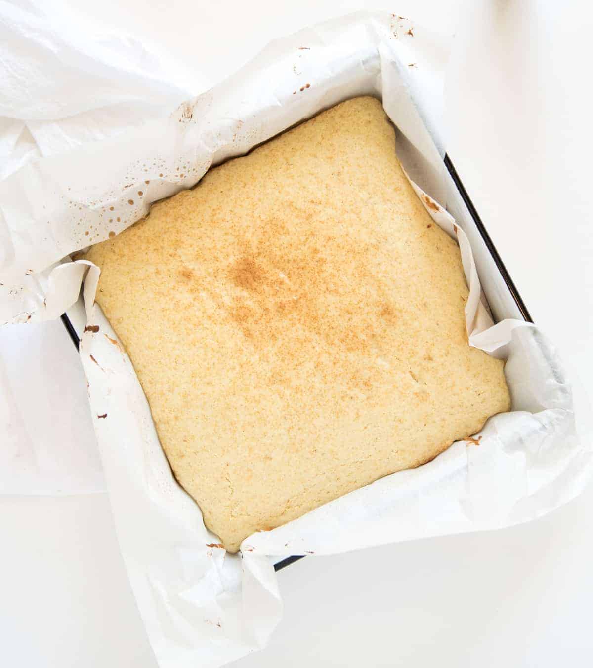 a square pan with a bake strawberry shortcake golden brown and ready for toppings.