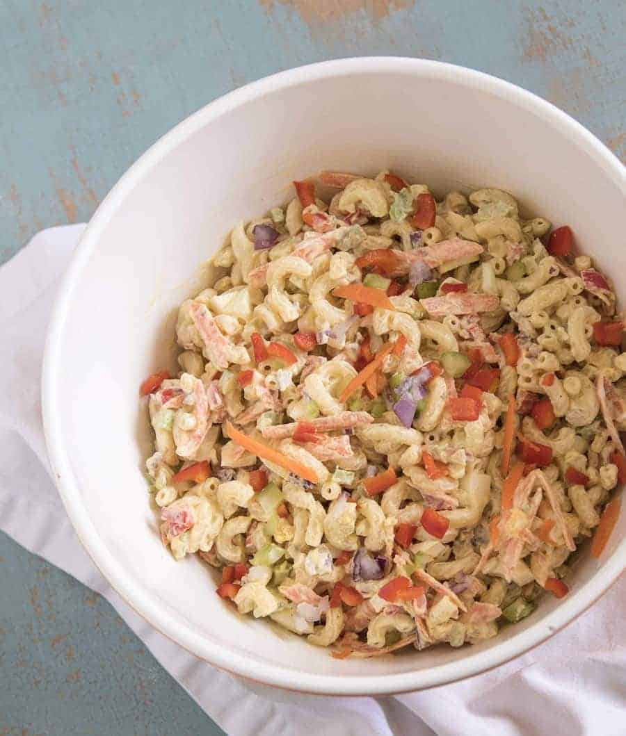 Classic Macaroni Salad in a white bowl resting on a white napkin.