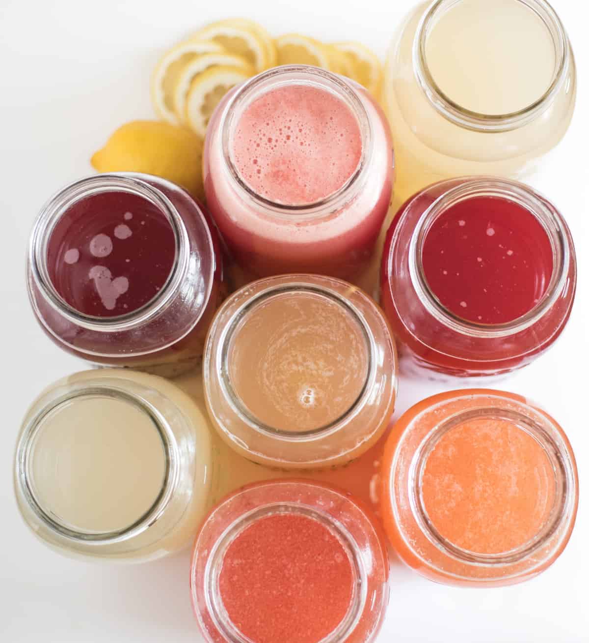 Top view of glass jars filed with different flavors of lemonade.