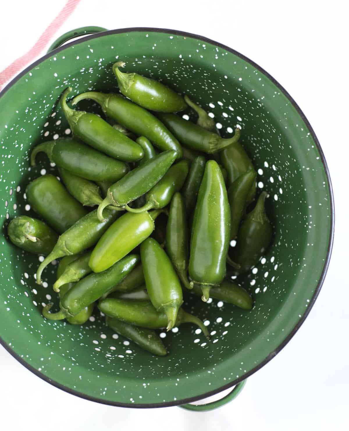 Top view of Jalapeños in a green colander.