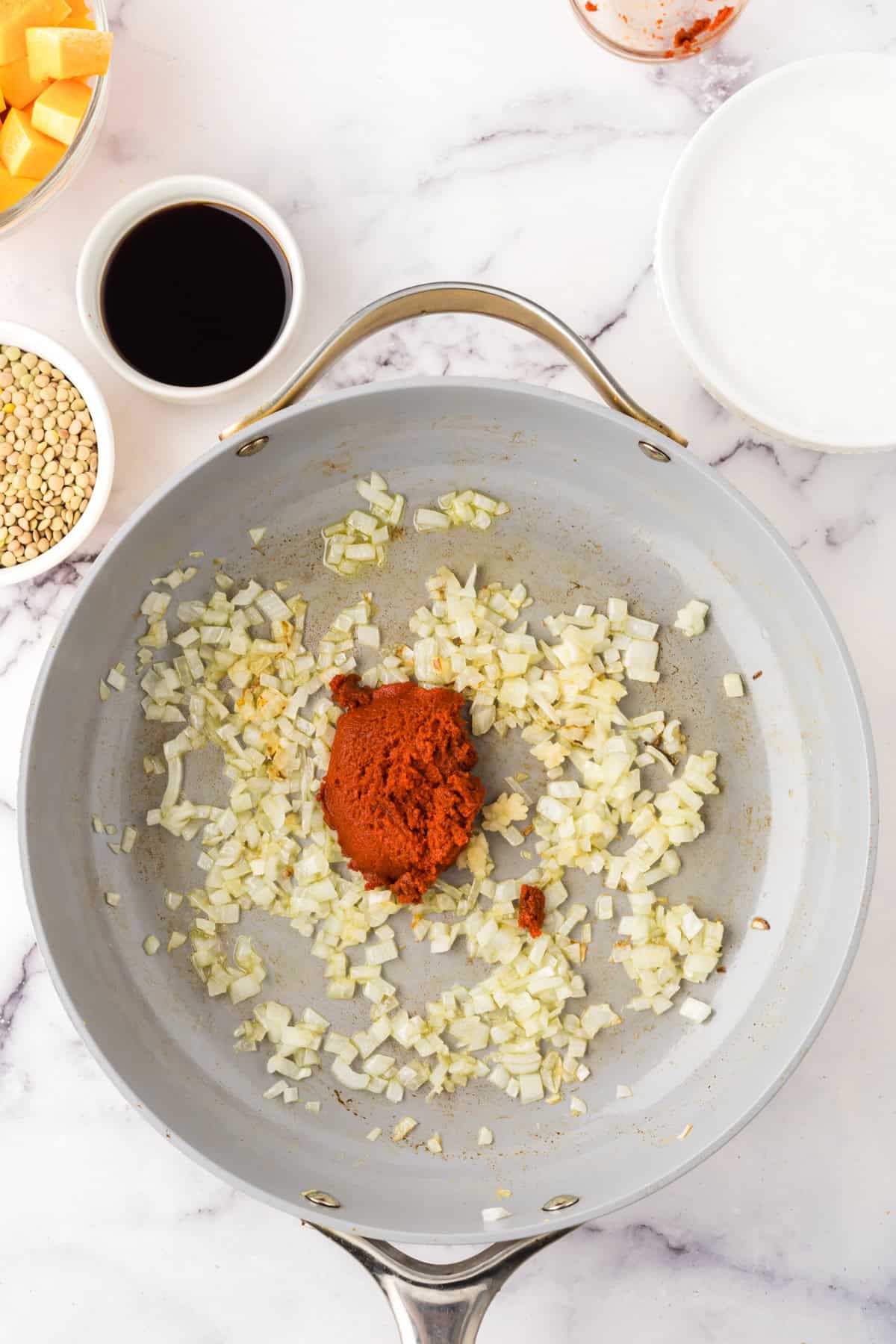 Garlic, onions and tomato paste in a pan.