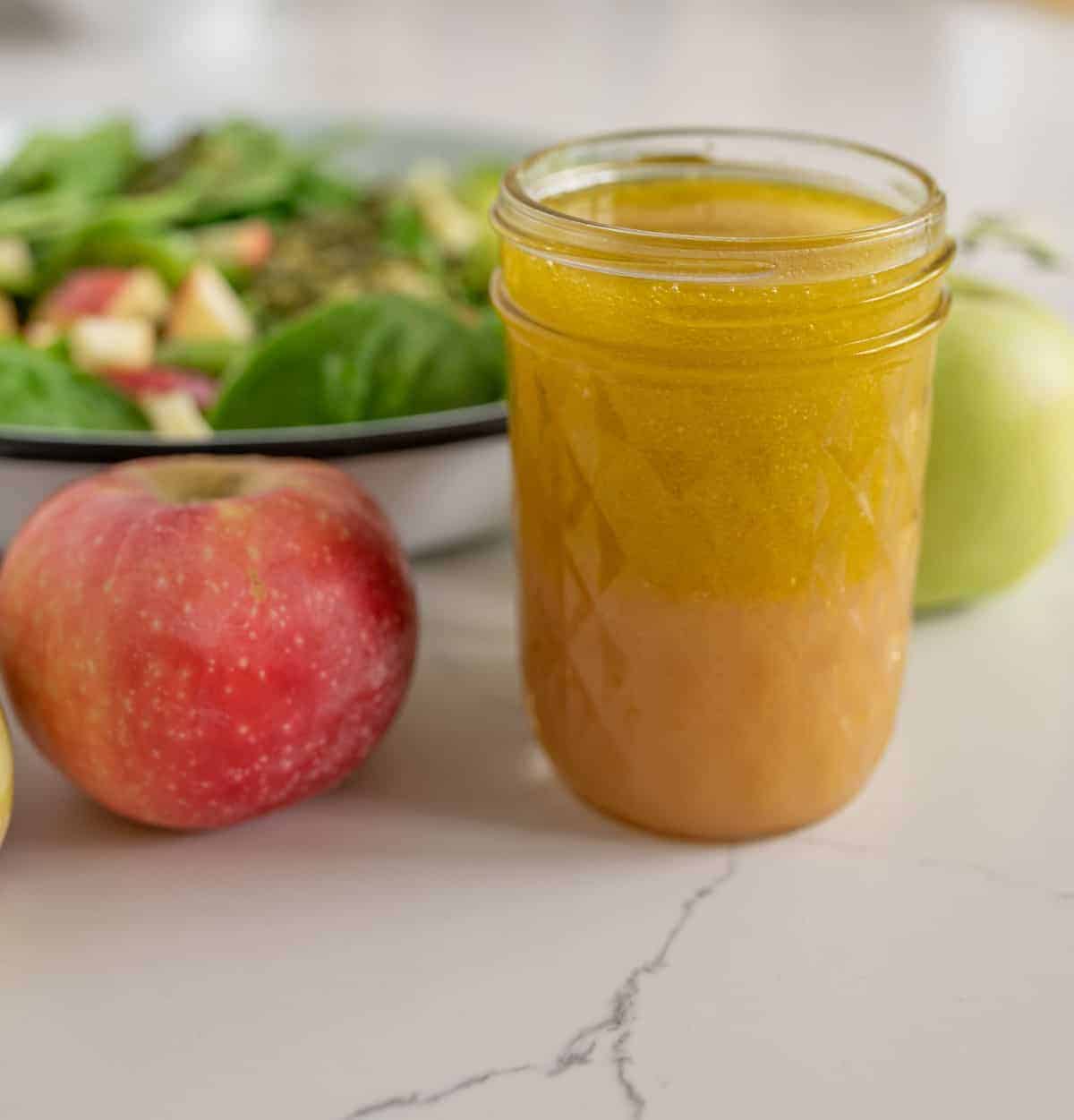 Quick and easy spinach salad recipe with apples, pumpkin seeds, and a simple flavor-filled apple vinaigrette dressing to go with it.