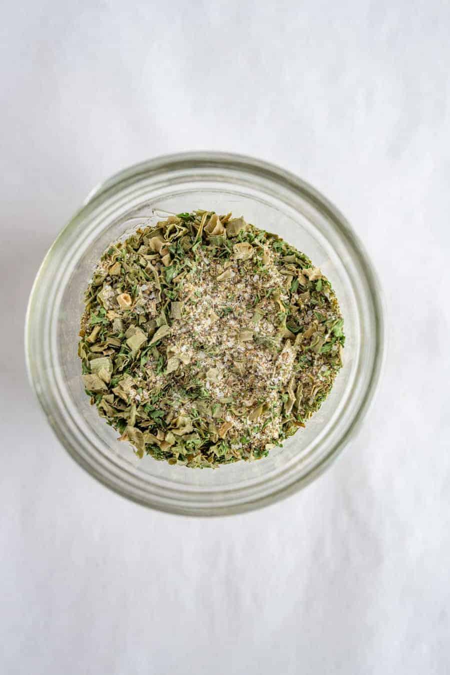 clear jar with mixture of dry herbs and spices.