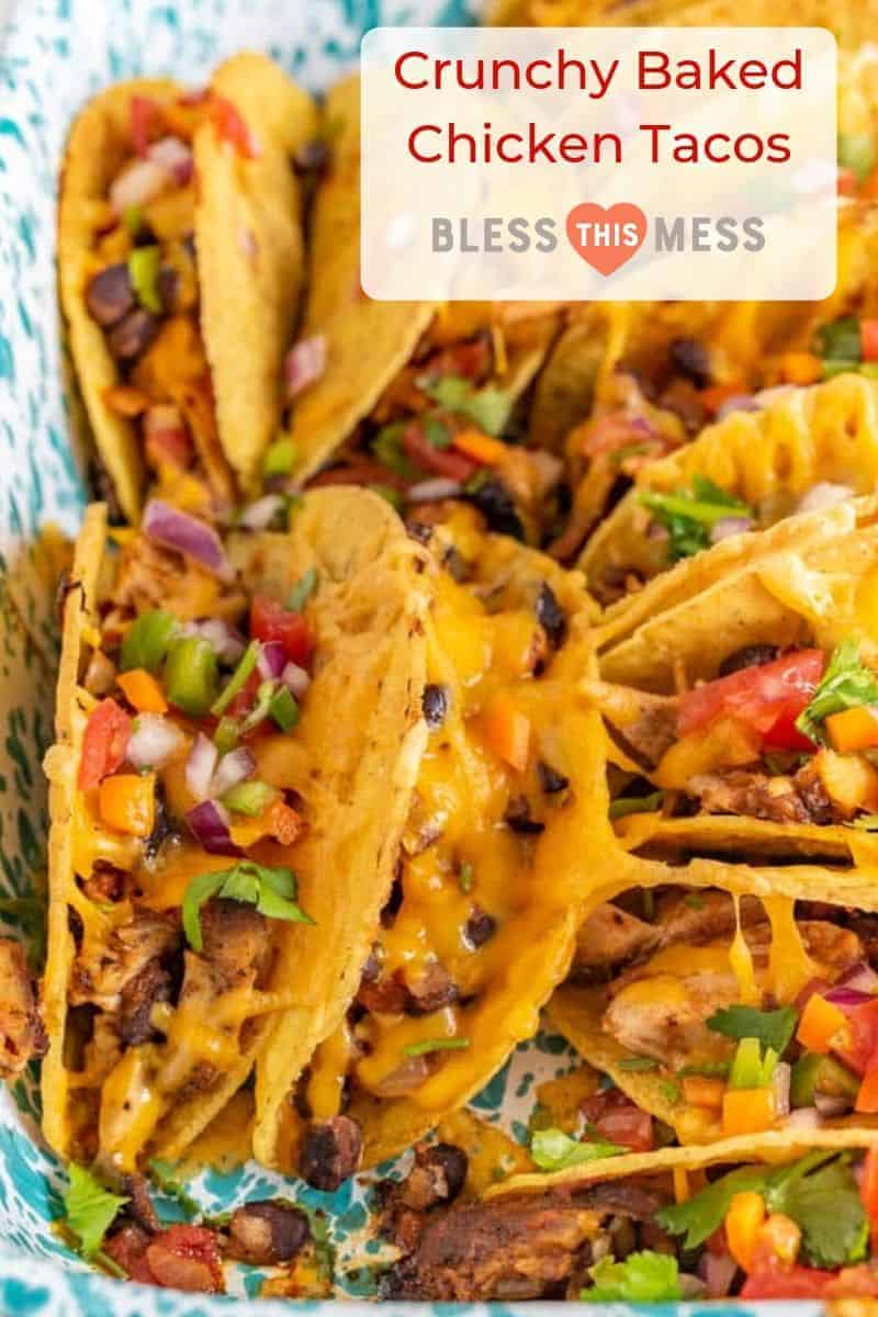 A close-up of baked chicken tacos filled with melted cheese, diced tomatoes, onions, jalapeños, and cilantro, arranged in a colorful dish. Text overlay reads “Crunchy Baked Chicken Tacos Rcova.”.