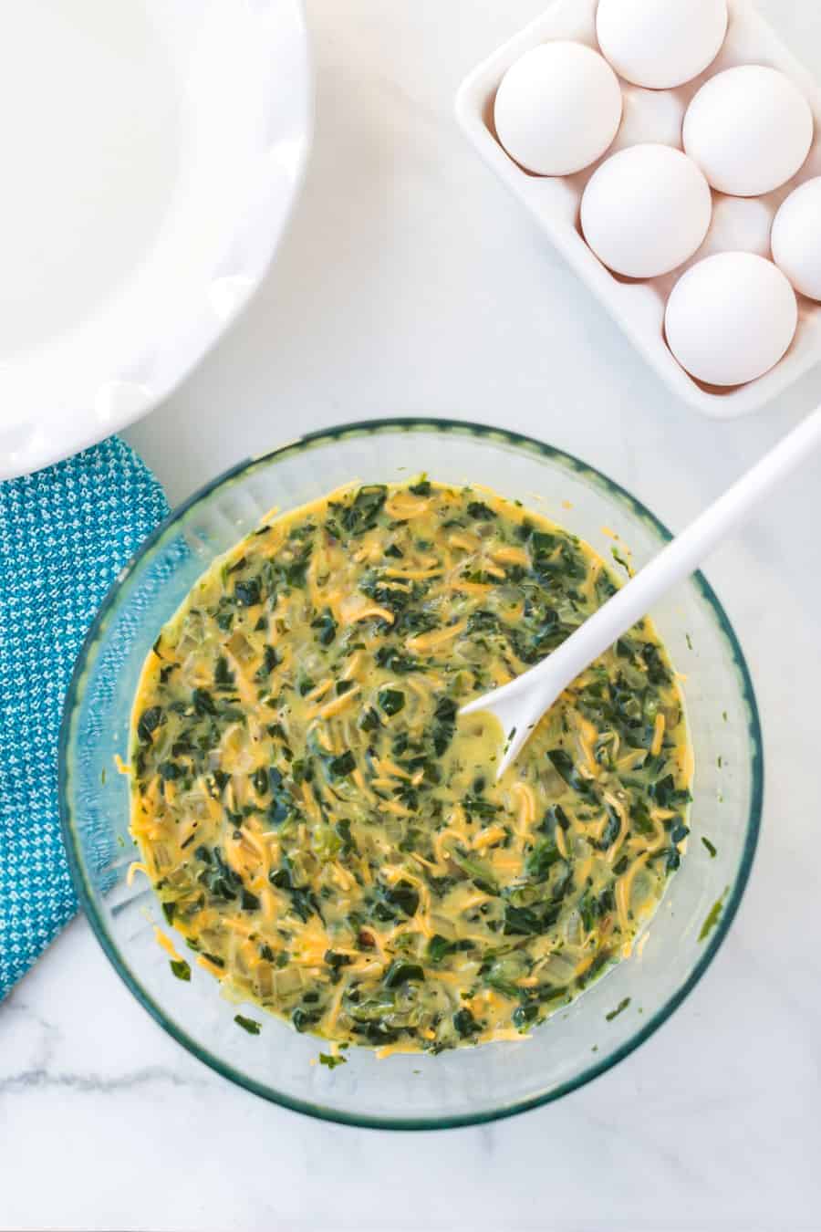spinach quiche mix in a clear glass bowl