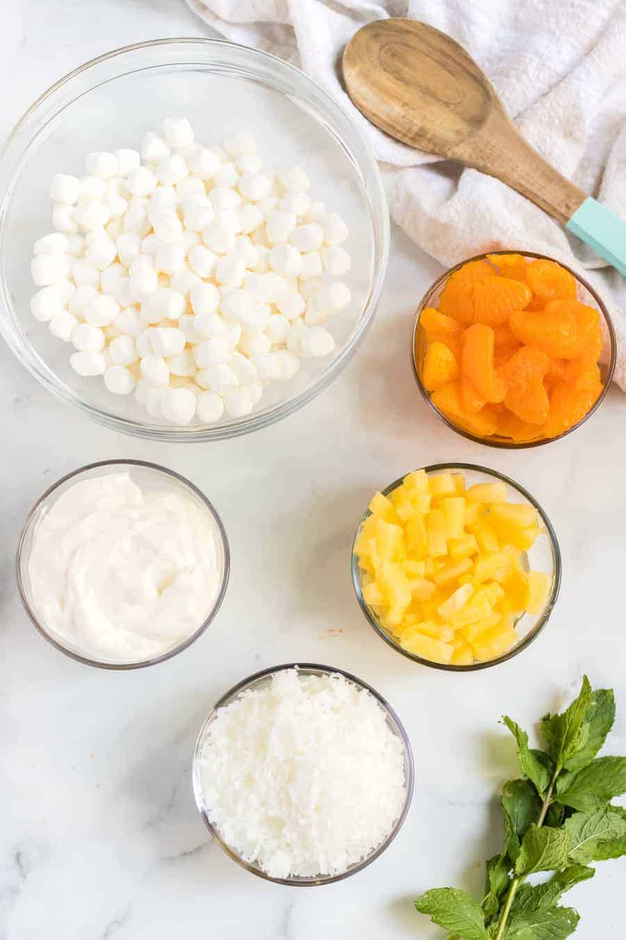 6 cup salad with oranges marshmallows and a cream fruit salad mix in a glass mixing bowl