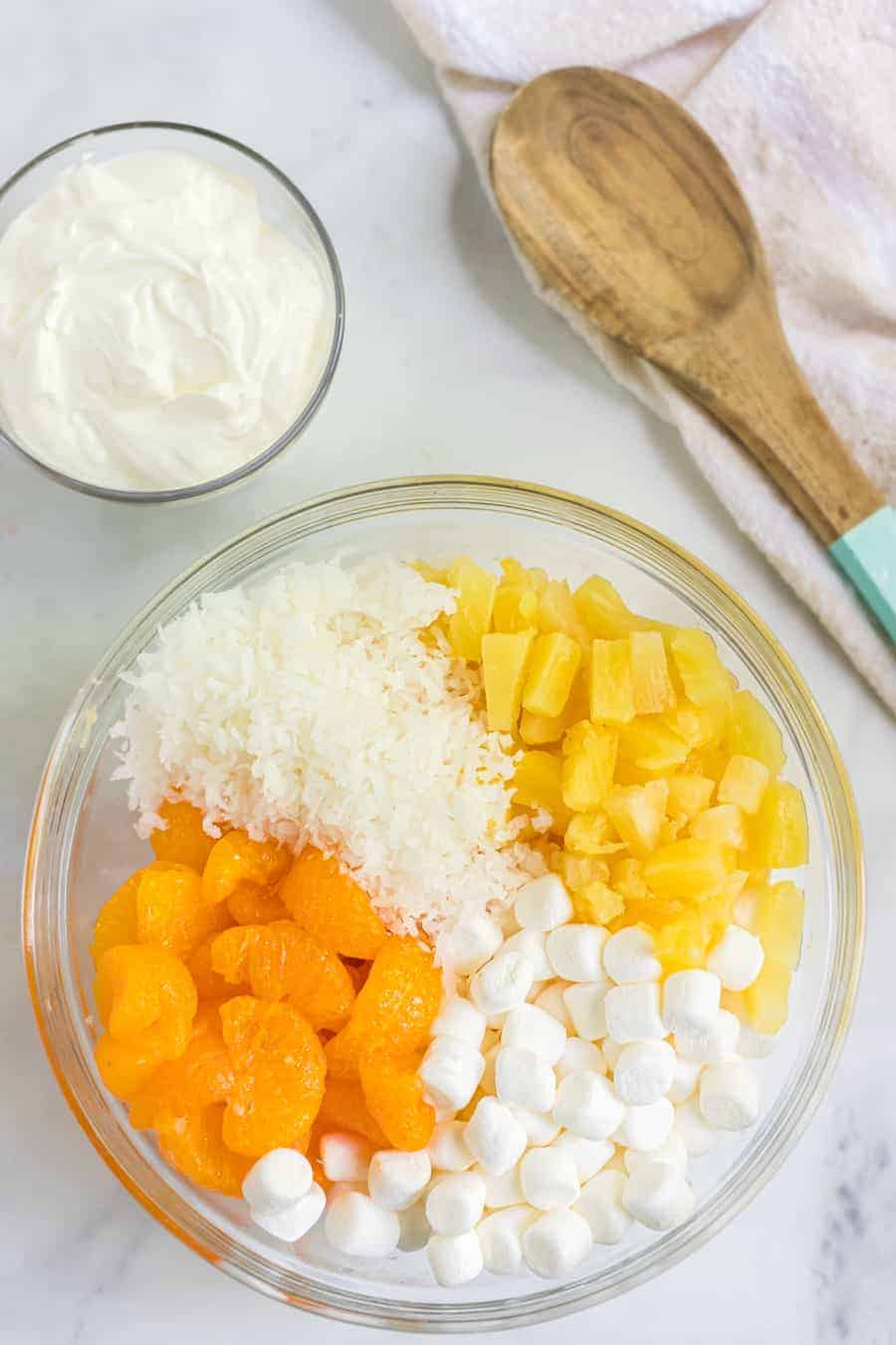 6 cup salad with oranges marshmallows and a cream fruit salad mix in a glass mixing bowl