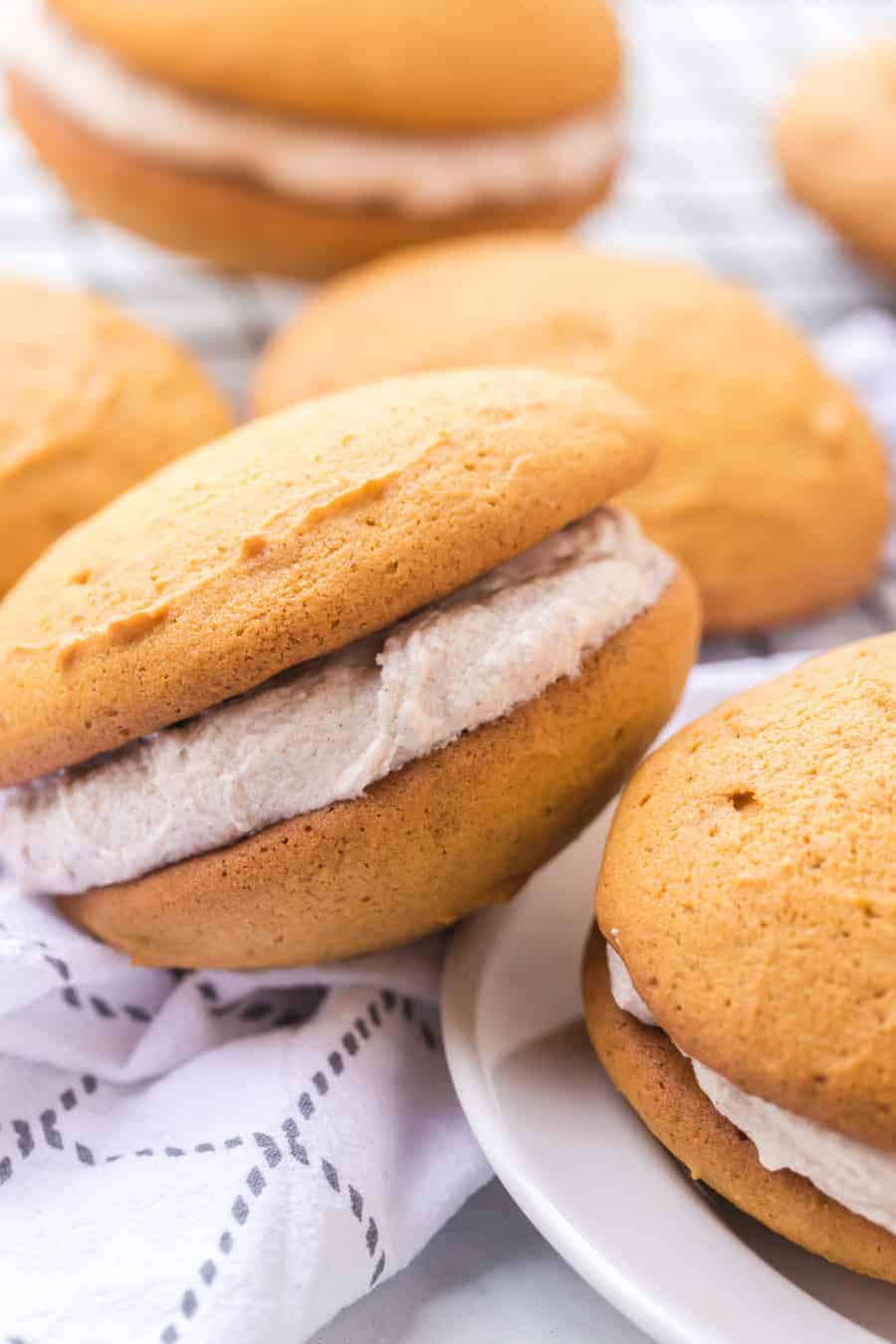 golden top and bottom with cinnamon speckled cream filling two whoopee pies stacked on top of each other.