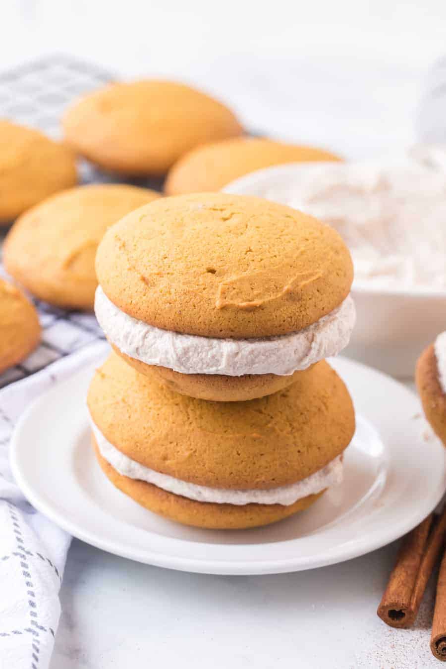 golden top and bottom with cinnamon speckled cream filling two whoopee pies stacked on top of each other.
