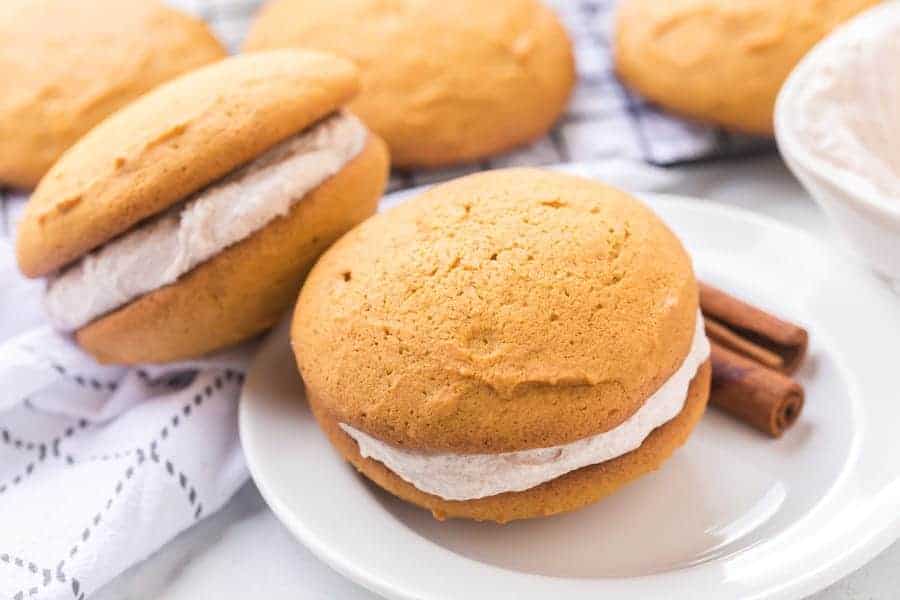 golden top and bottom with cinnamon speckled cream filling two whoopee pies stacked on top of each other.