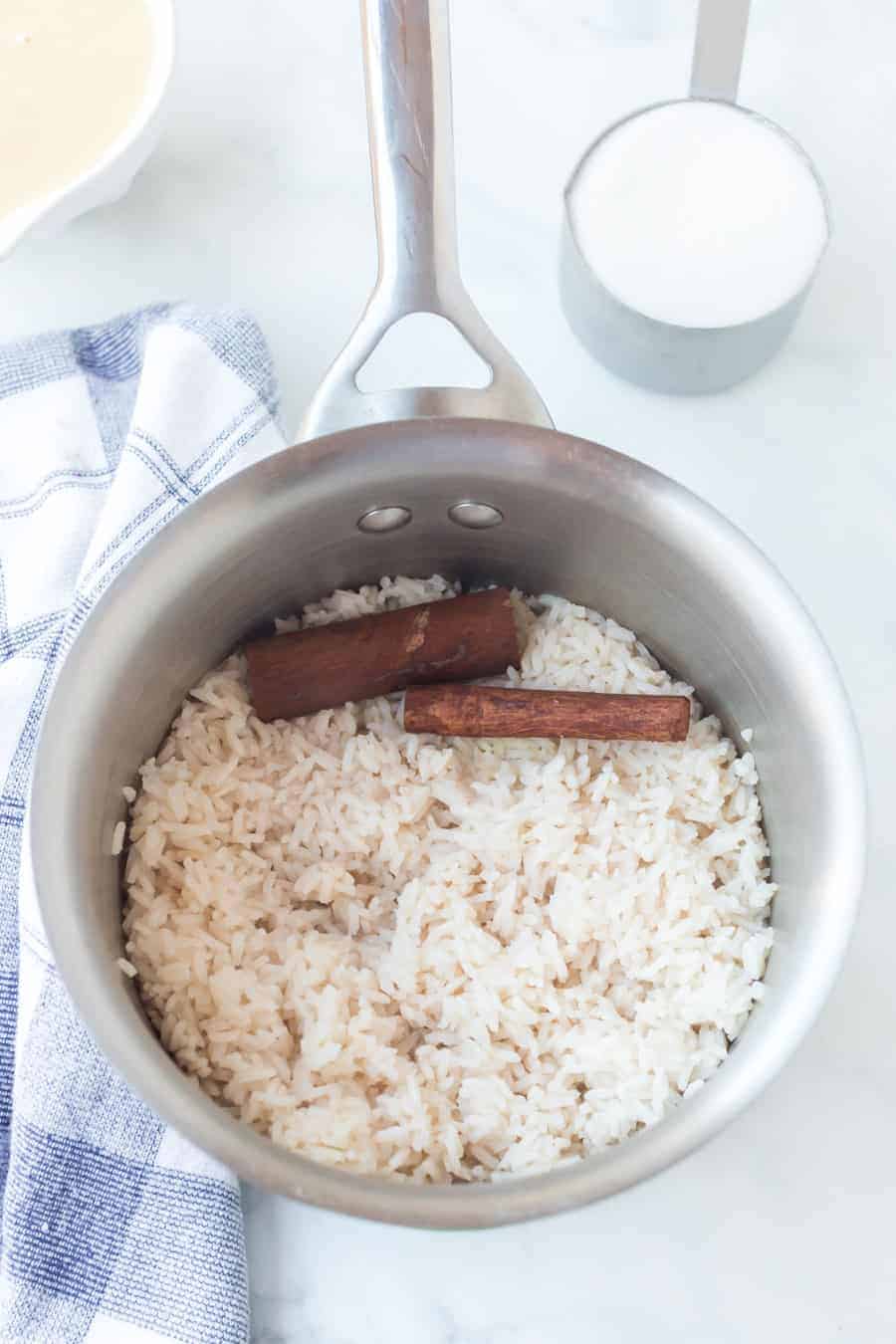 rice with cinnamon sticks in a pot.