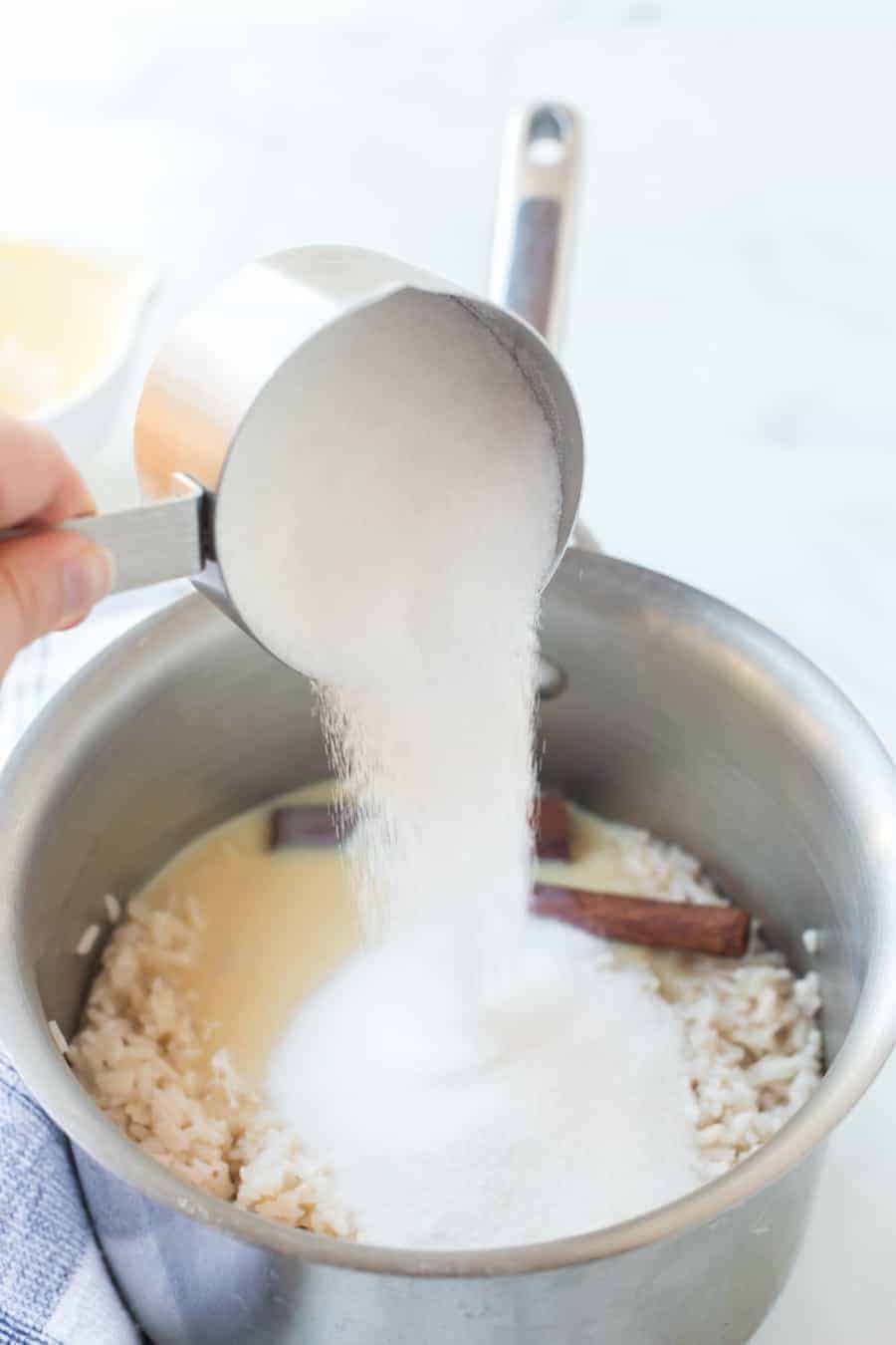sugar being mixed into the cinnamon and rice pudding mixture