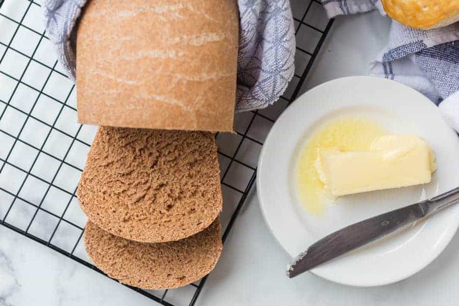 whole wheat bread on a cooling rack with butter on the side