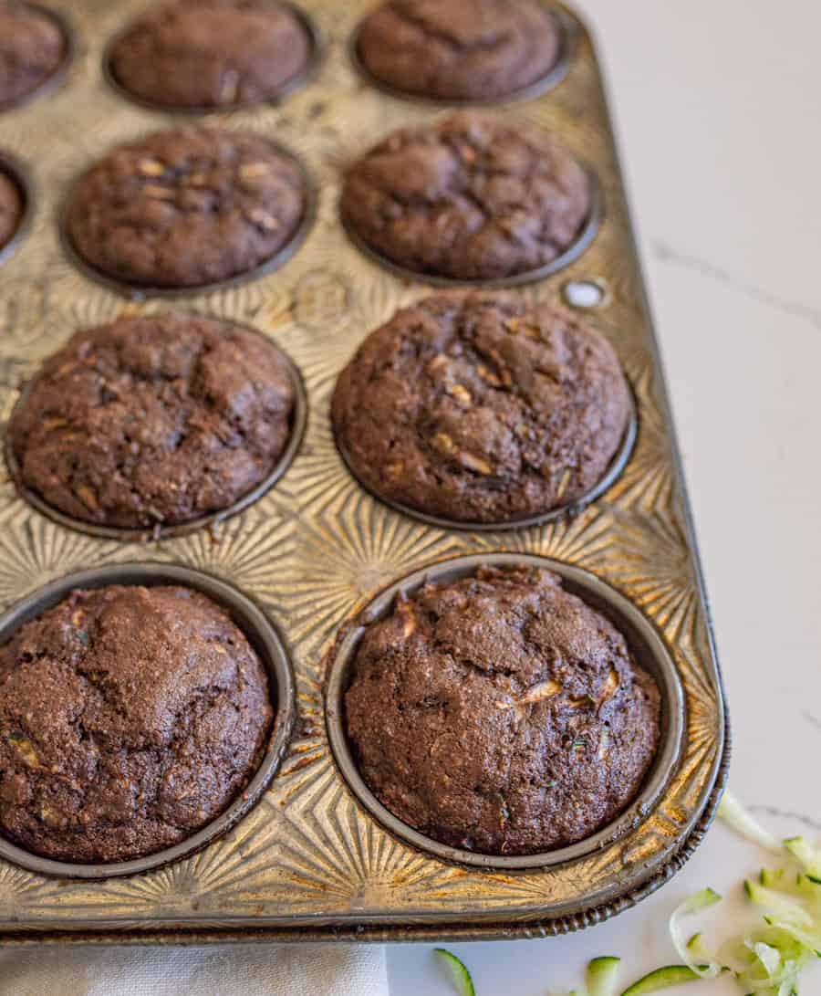 chocolate zucchini muffins in a small muffin tin.