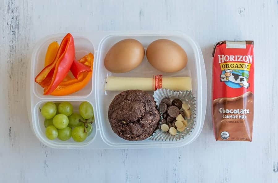 tupperware with compartments for different lunch ingredients and chocolate milk on the side.