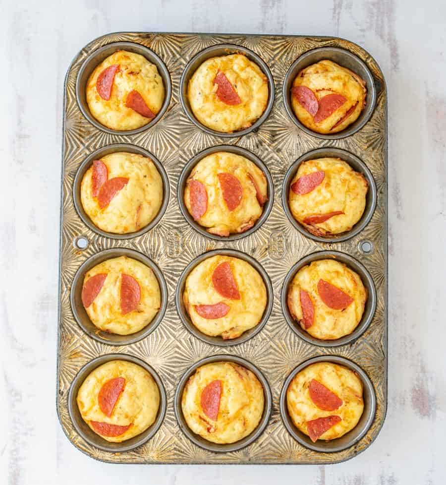 Easy pepperoni pizza muffins sitting in a muffin tin.