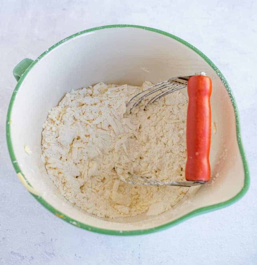 ingredients for all butter pie crust in a green bowl.