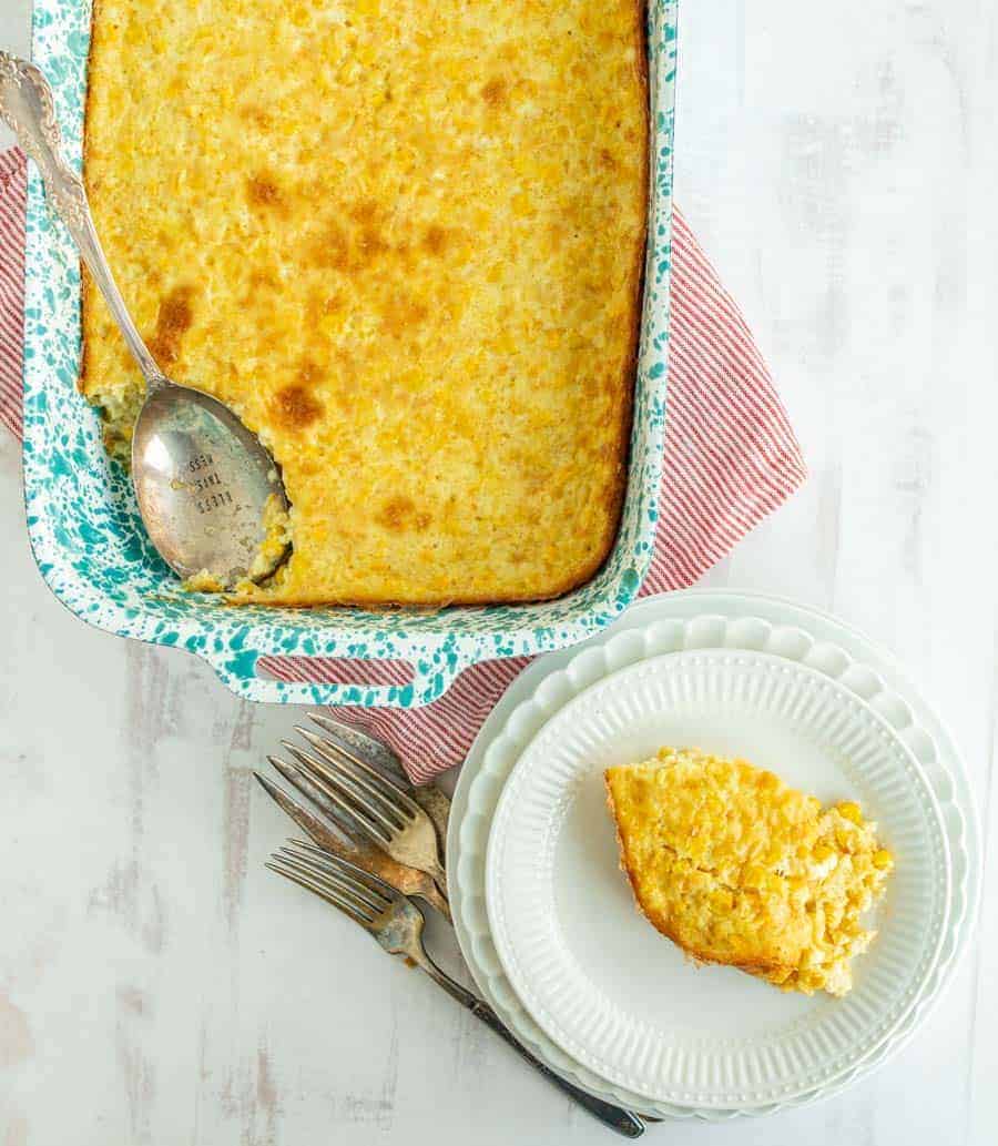 corn pudding in baking dish corner piece cut out.