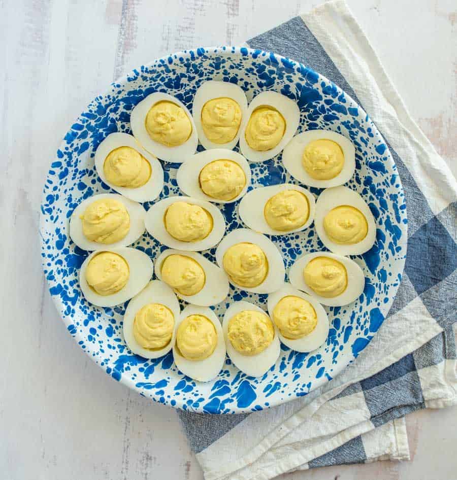 top view of deviled eggs on a blue and white plate.