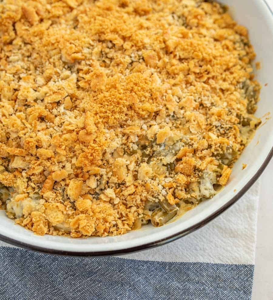 a circular baking dish with crispy onions on top a traditional green bean caserole.